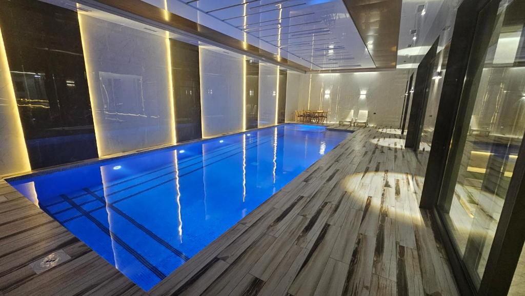 a swimming pool in a building with blue water at Dacha Akua Relax in Chorwoq