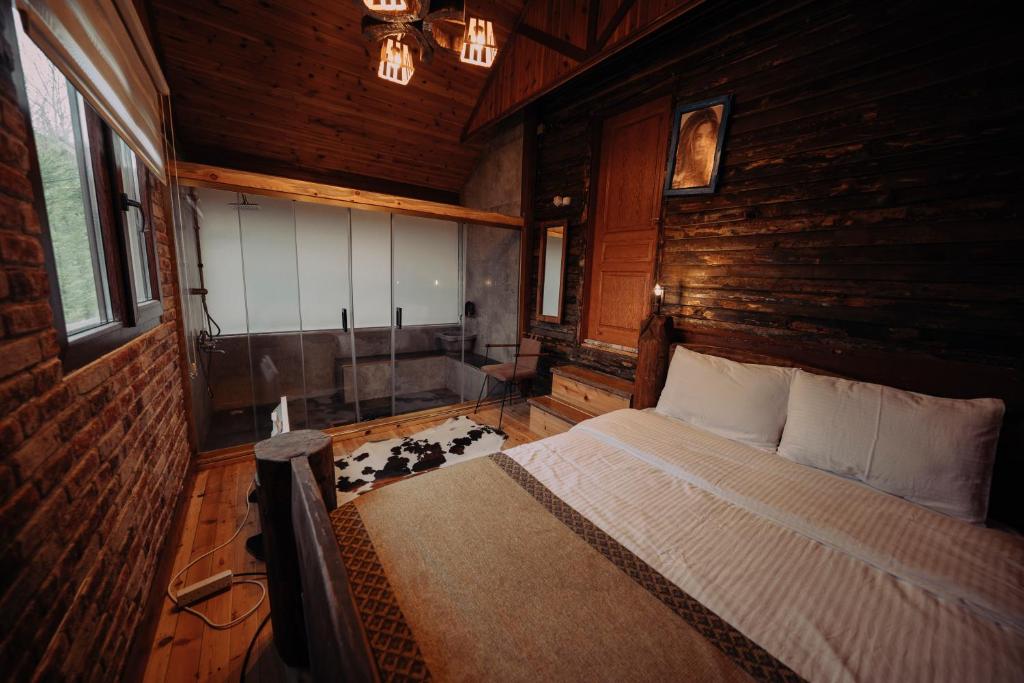 a bedroom with a bed in a wooden room at Bolu'da dağ evi in Demirciler