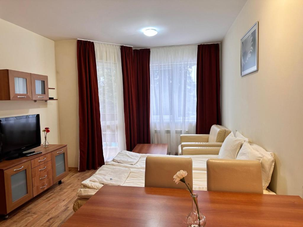 a hotel room with a bed and a tv at Luxury one bed apartment with hydro bath in Royal Plaza in Borovets