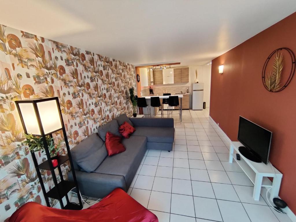 uma sala de estar com um sofá e uma televisão em Appartement à côté de Disneyland Paris CK-triomphe em Esbly