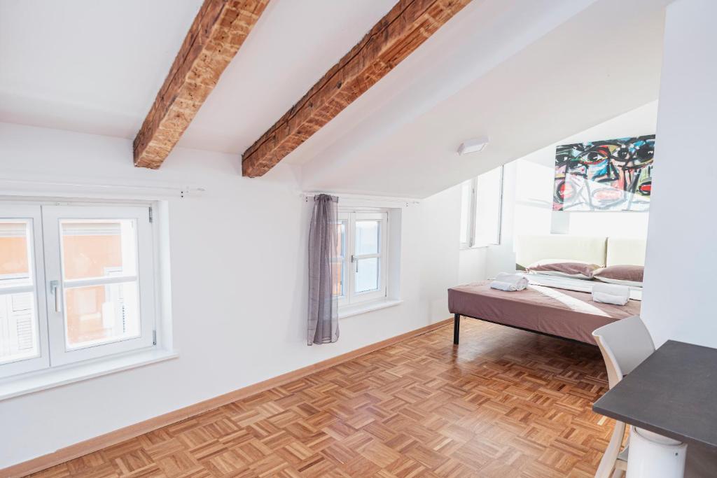 a white room with a bed and two windows at Le Finestre Boutique Apartments in Trieste