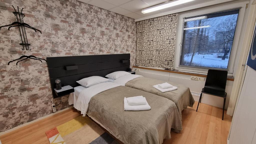 a bedroom with a large bed with two towels on it at Aparthotel Clock 2 in Kotka