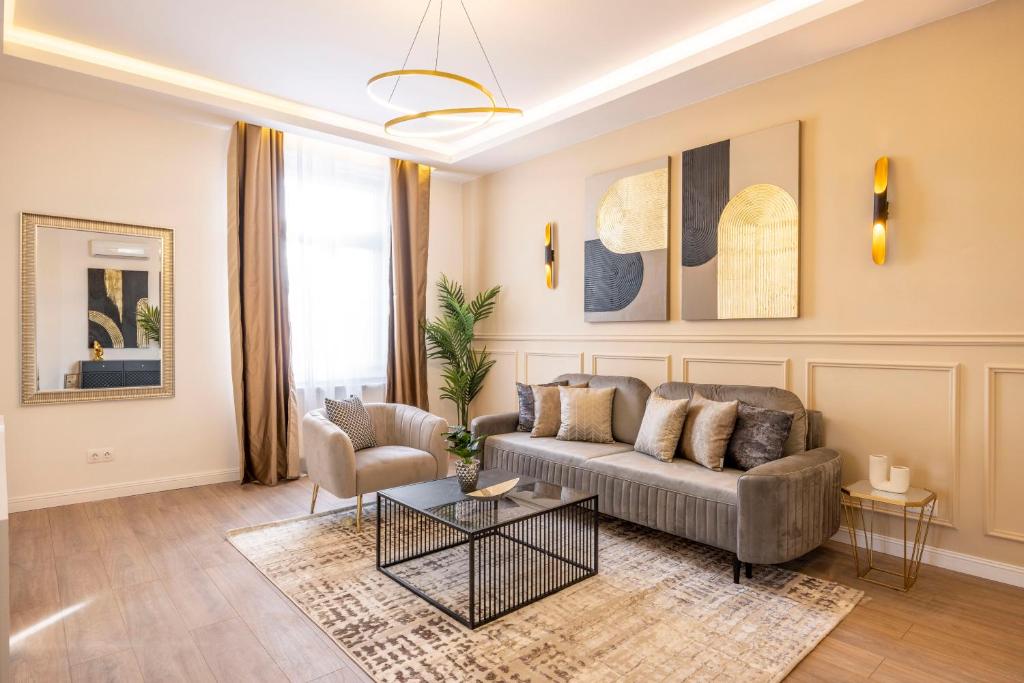 Luxury & Classy Central Apartment with 3BEDRM, 2BATHRM في بودابست: غرفة معيشة مع أريكة وطاولة