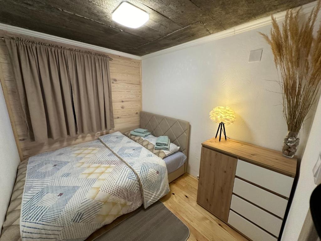 a small bedroom with a bed and a desk at Blue Village Lux in Kolašin