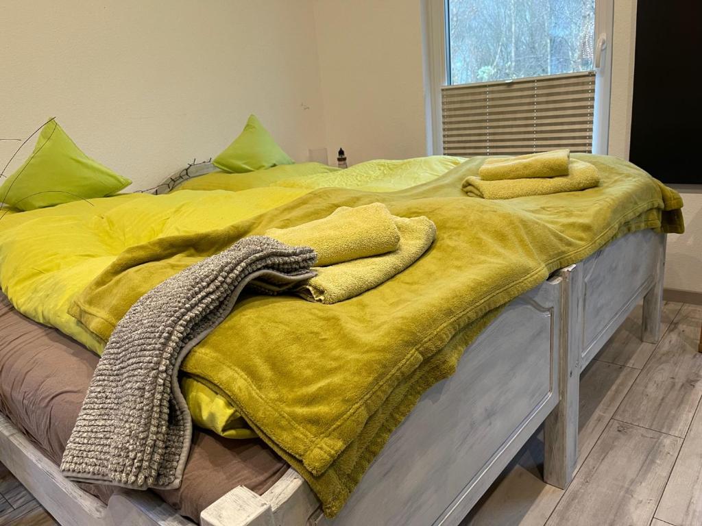 a bed with a yellow blanket on top of it at NatureCamp Cuxhaven in Cuxhaven