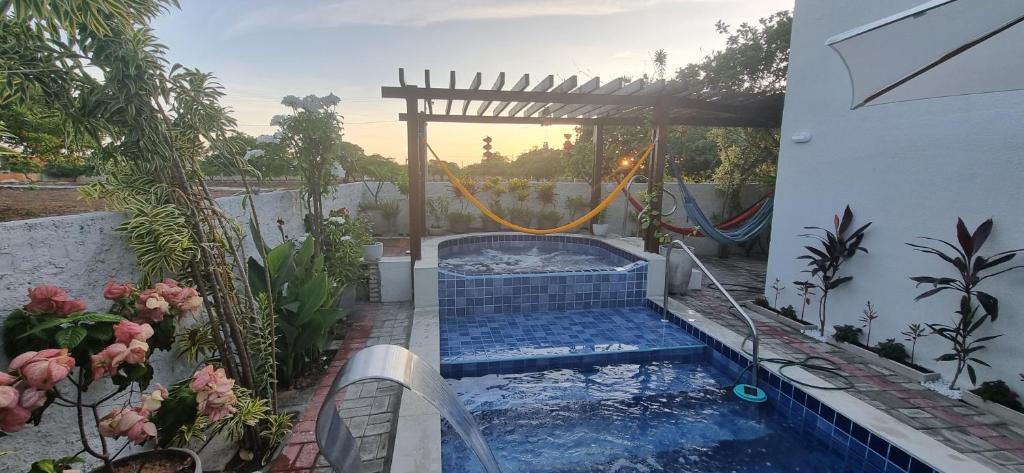 uma piscina num quintal com um gazebo em Bella casa três suites com spa e piscina em condomínio fechado em Aracati