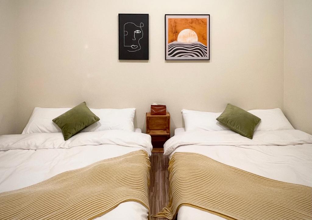 twee bedden naast elkaar in een kamer bij 青青小院 Qing Yard in Tainan