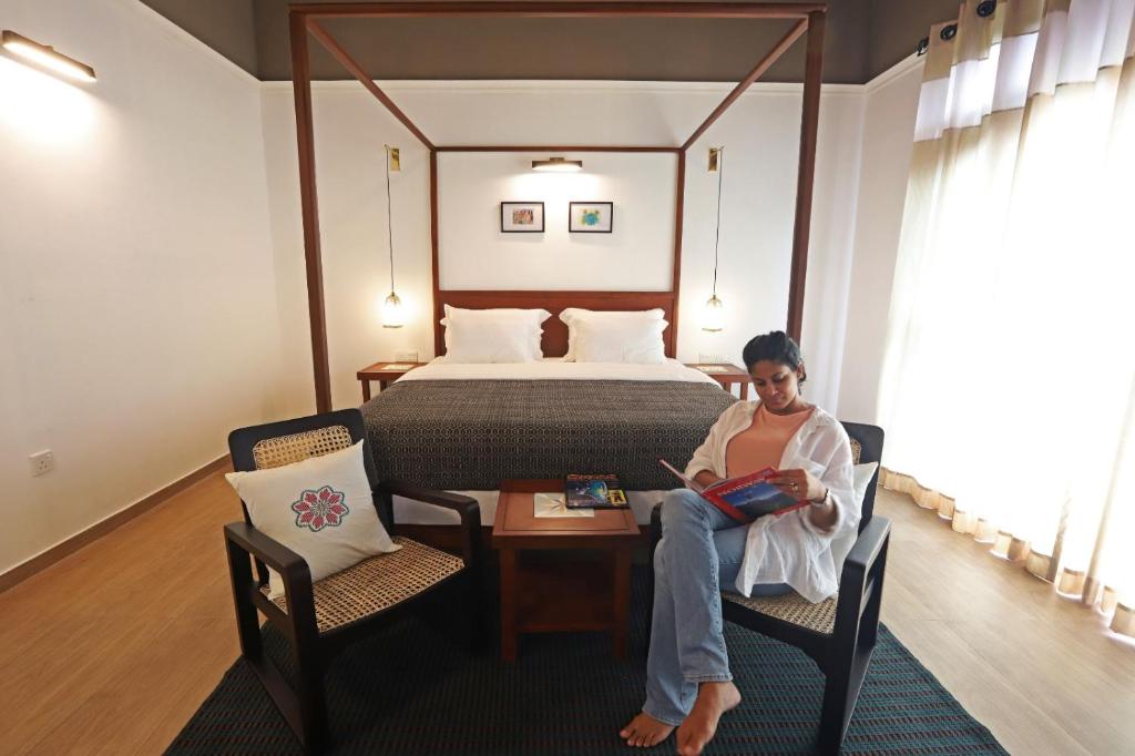 een vrouw in een stoel in een hotelkamer bij Gannoru Hatana Villa in Kandy