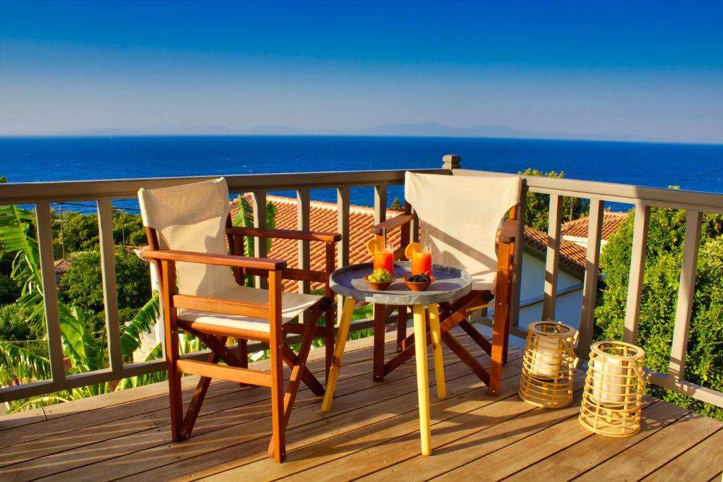 a table and two chairs on a deck with the ocean at Kleine Villa mit Meerblick, Samos, Griechenland in Samos