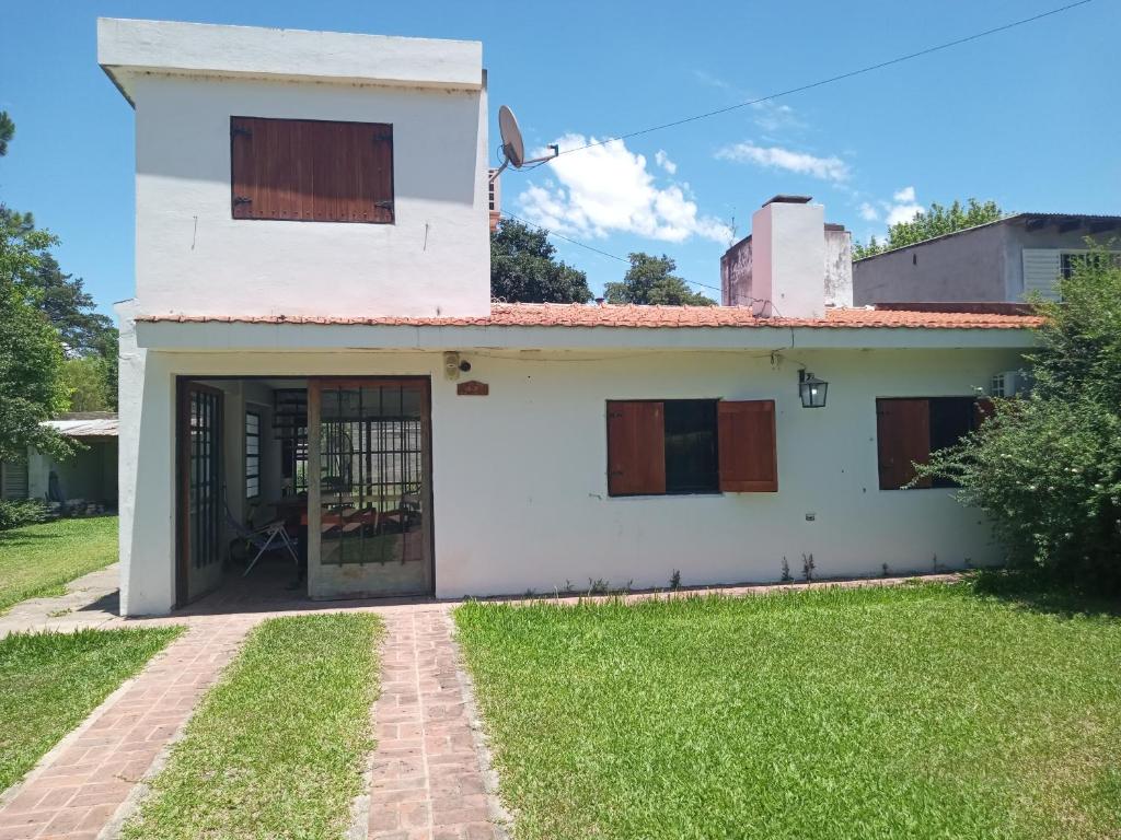 una casa blanca con una puerta y un patio de césped en LaAzucena2 en Bialet Massé