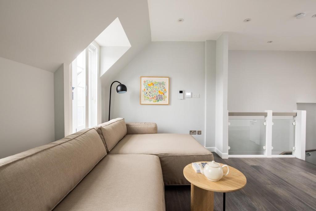 ein Wohnzimmer mit einem Sofa und einem Tisch in der Unterkunft Hausd - Soho in London
