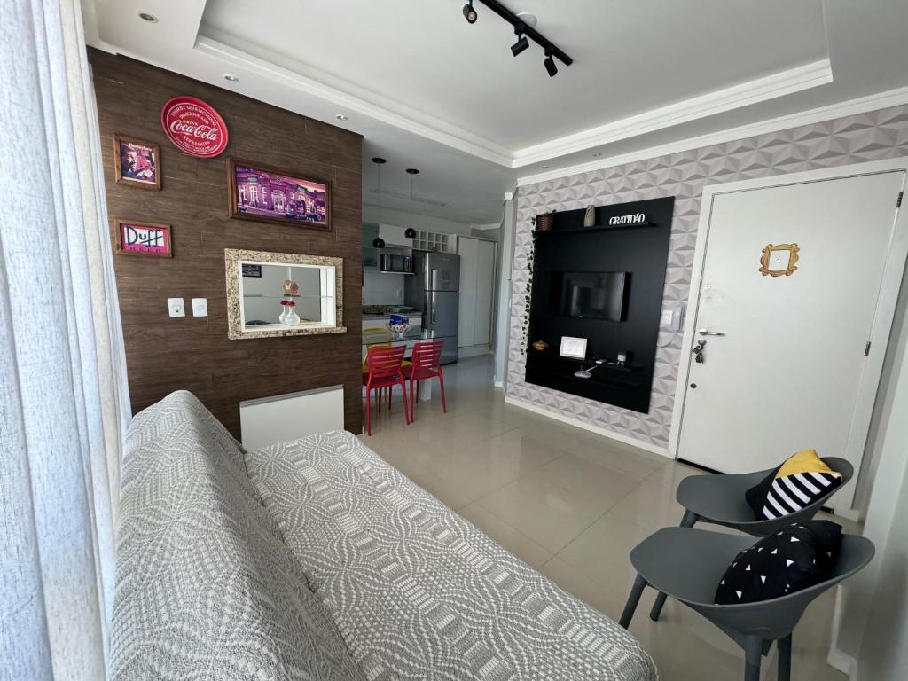 sala de estar con sofá y comedor en Apartamento 2 quartos a 2 quadras da praia, en Capão da Canoa