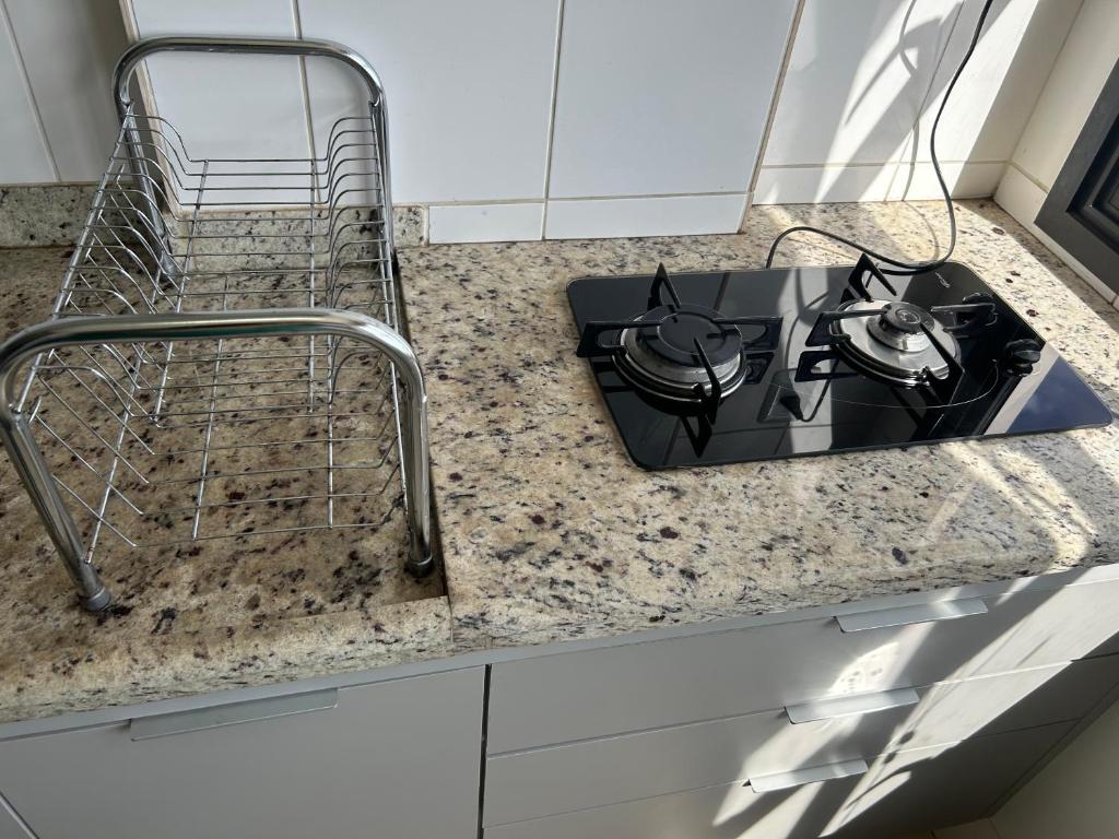 a kitchen counter with a stove and a sink at Flat completo no centro. in Palmas