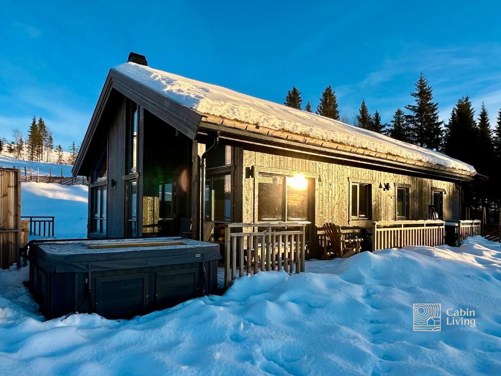 a log cabin in the snow in the winter at New cabin with jacuzzi, sauna and ski inout in Svingvoll