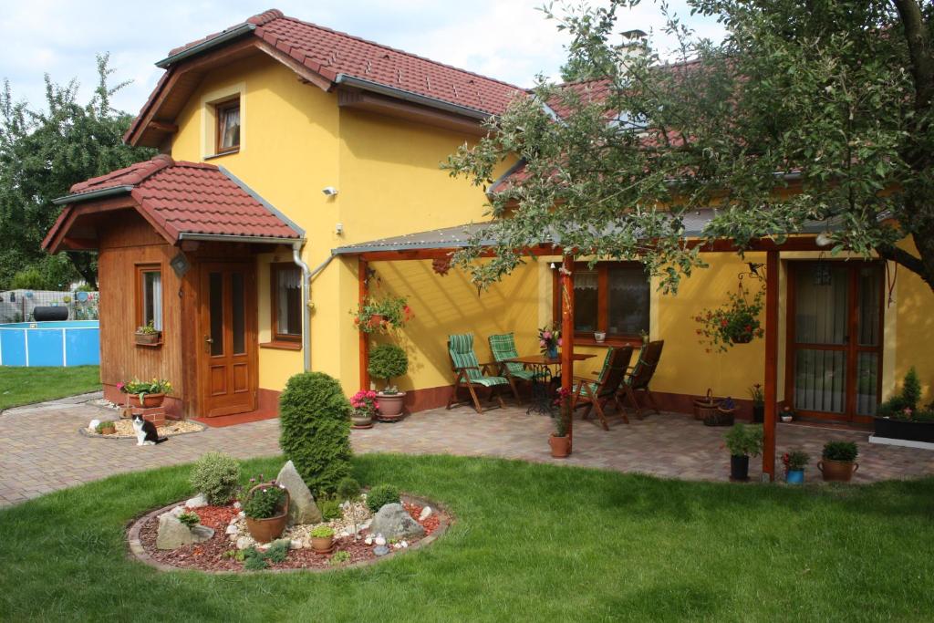 a yellow house with a table and chairs in a yard at Apartment BENCI in Jindrichuv Hradec
