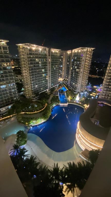a view of a pool at night with tall buildings at Azure Urban Resort Residences in Manila