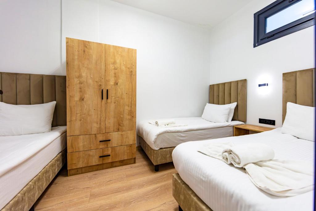a bedroom with two beds and a wooden cabinet at Mia Mia Suites in Istanbul