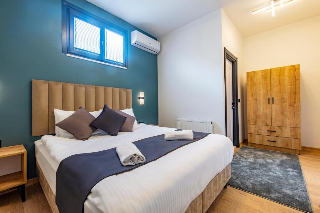 a bedroom with a large bed with a blue wall at Mia Mia Suites in Istanbul
