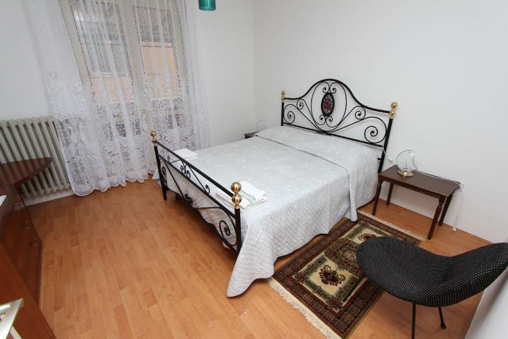 a bedroom with a bed and a table and a chair at Apartment Key in Rovinj