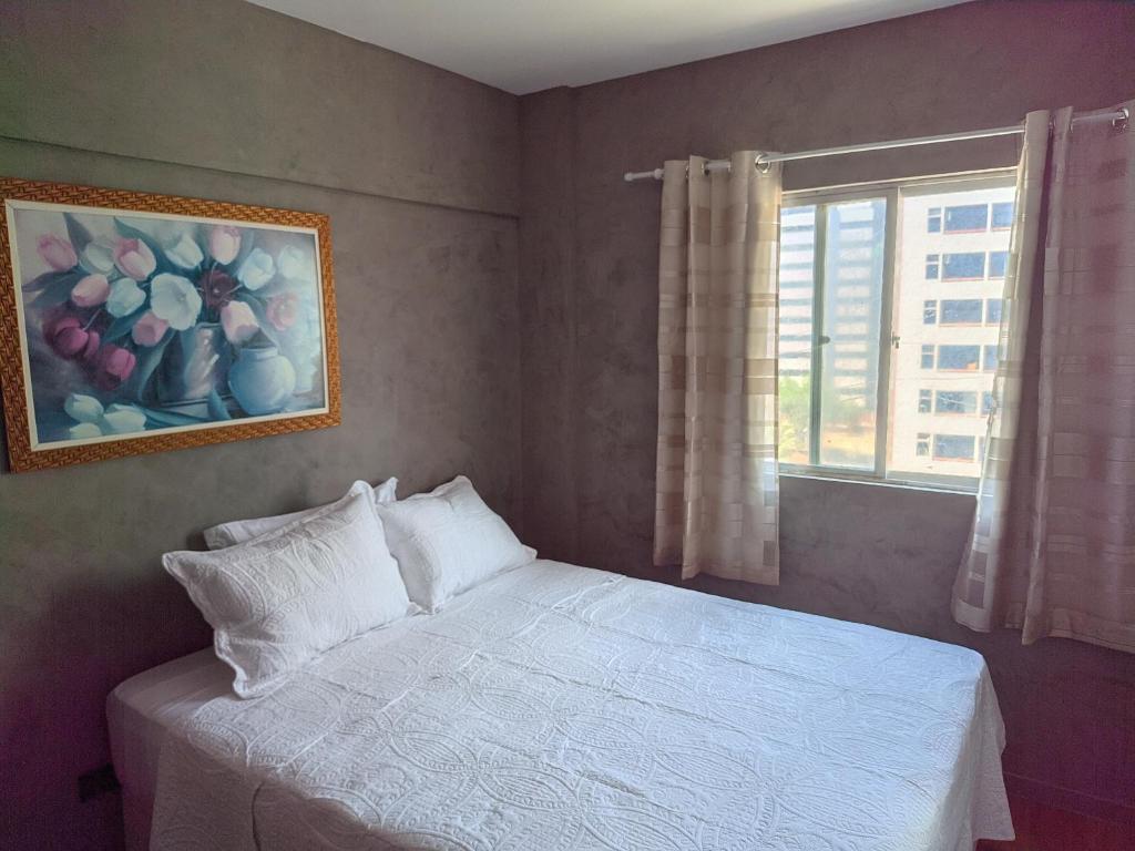 um quarto com uma cama branca e uma janela em Seu Apê Ponta Verde- 02 QUARTOS - 2 banheiros - Ao lado do restaurante Janga em Maceió
