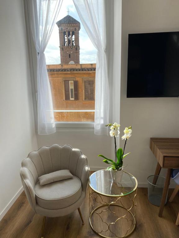 a living room with a chair and a table and a window at Belltower Elegans in Rome