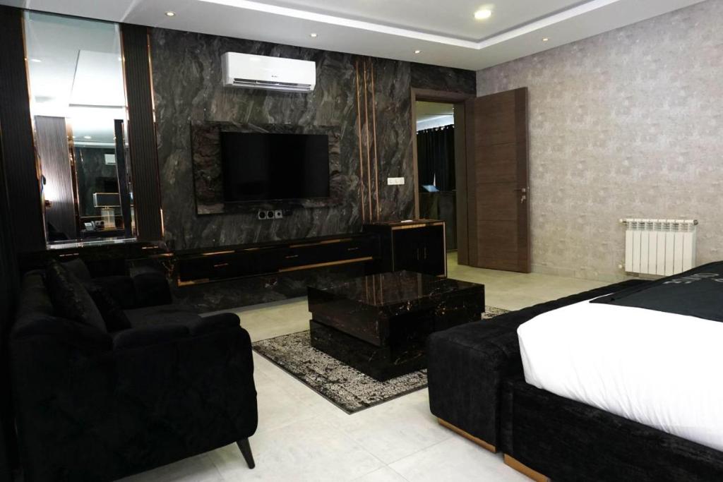 a bedroom with a bed and a tv and a couch at Hotel Oasis by Signature in Islamabad