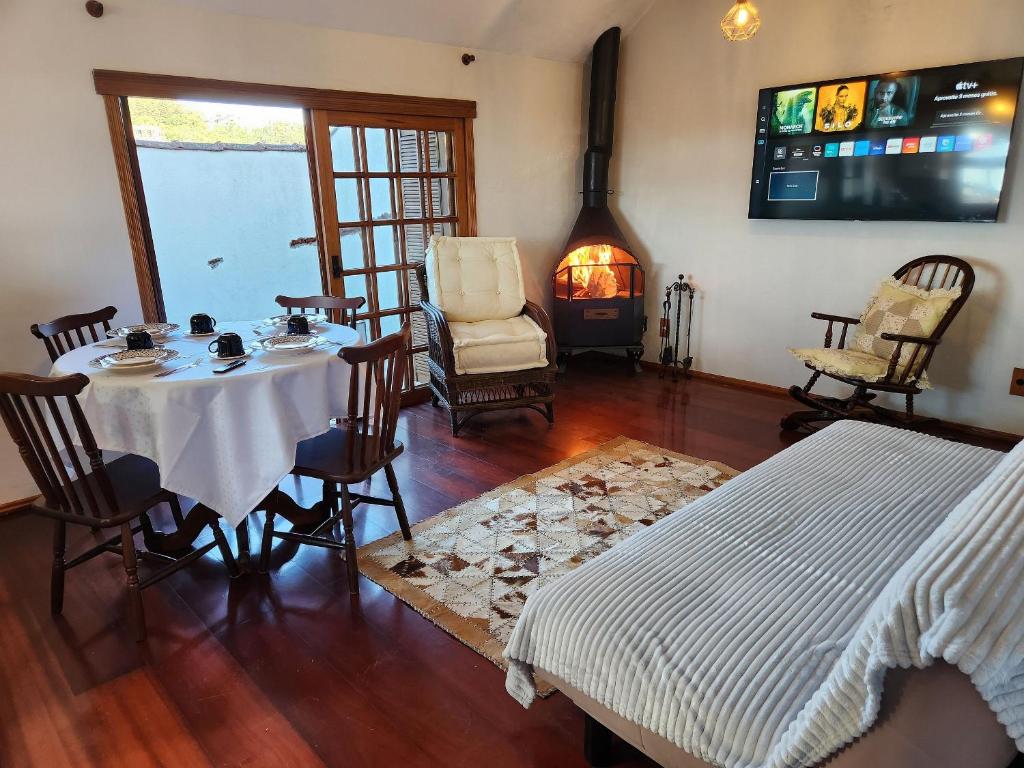 een eetkamer met een tafel en een open haard bij Apartamento a 150m da Rua Coberta in Gramado