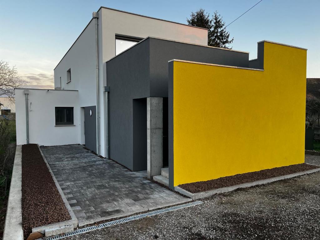 une maison avec un mur jaune dans l'établissement Près colmar 6, 