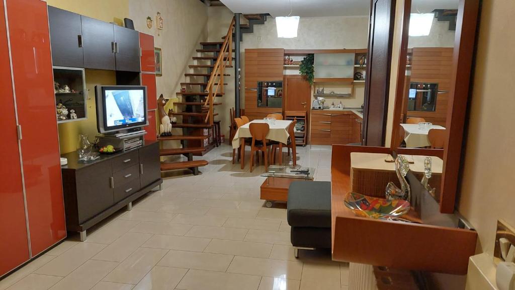 a room with a dining room and a kitchen with a television at Appartamento Andromeda con 3 camere da letto, Parcheggio privato e 2 Bagni in Potenza