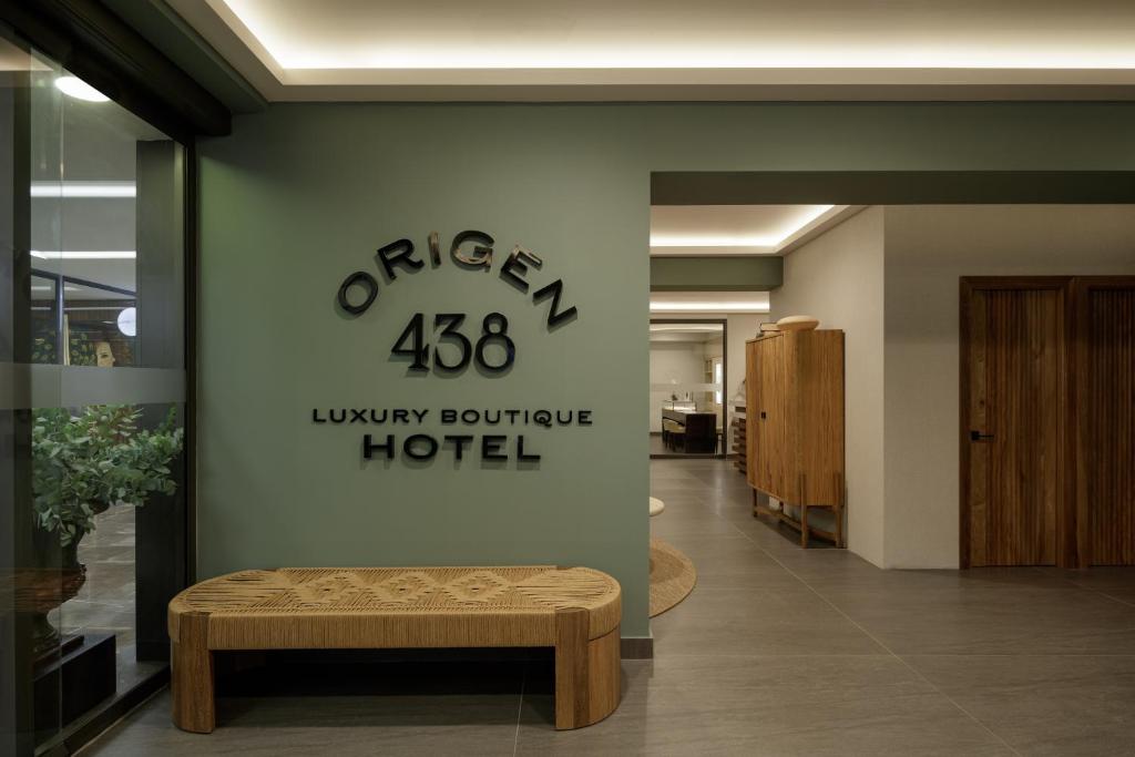 a sign for a hotel with a bench in a hallway at Origen 438 Luxury Boutique Hotel in Guadalajara