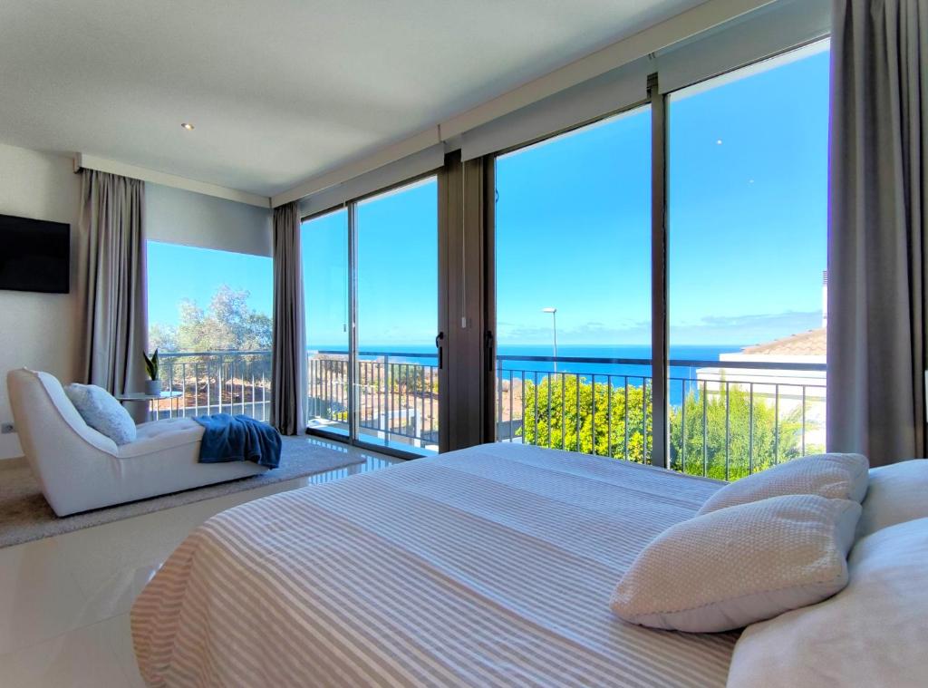 een slaapkamer met een groot bed en grote ramen bij Villa Boutique La Quinta in Santa Úrsula