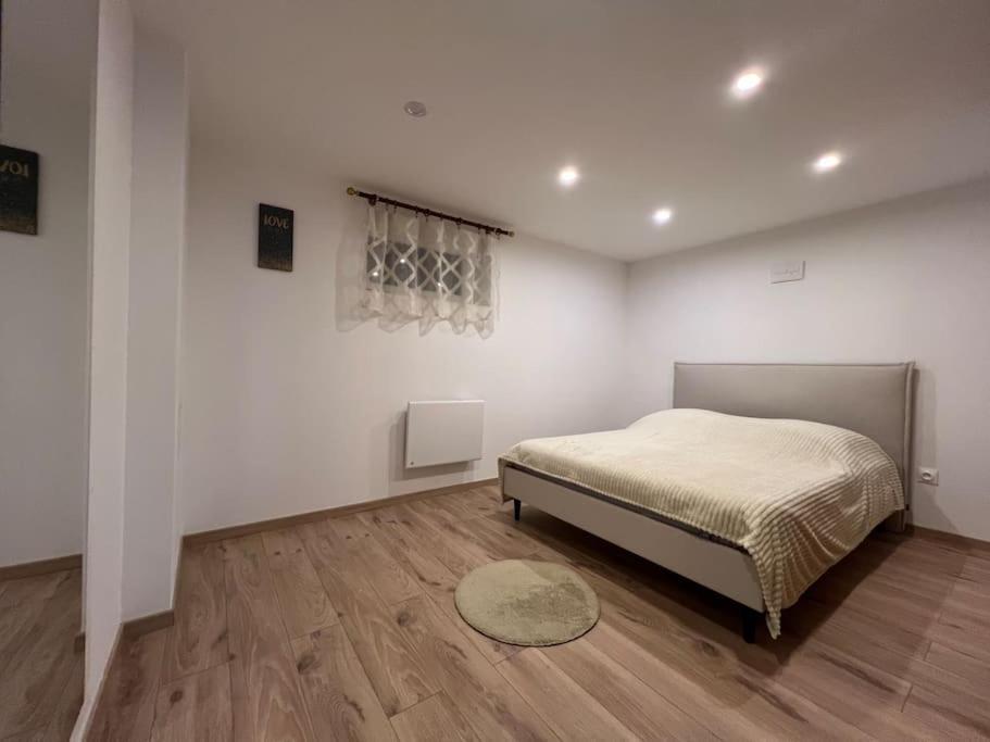 ein Schlafzimmer mit einem Bett in einem weißen Zimmer in der Unterkunft Charmant appartement Cosy in Reichstett