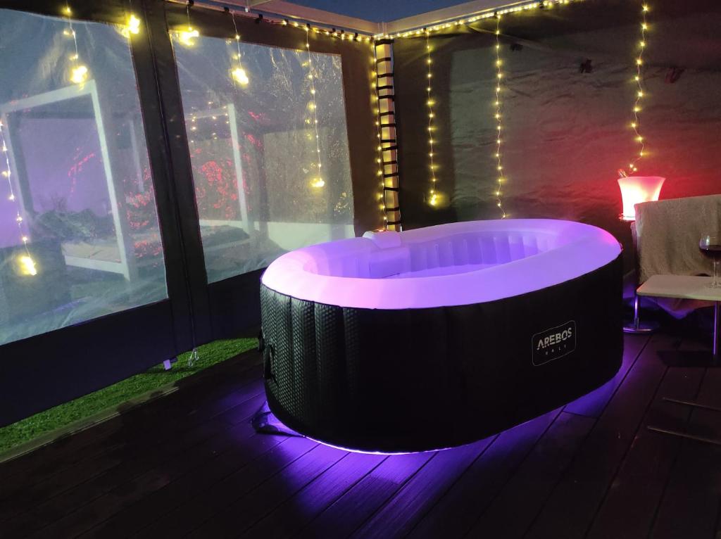 eine Whirlpool-Badewanne in einem Zimmer mit Beleuchtung in der Unterkunft Ático Rilque in Ronda