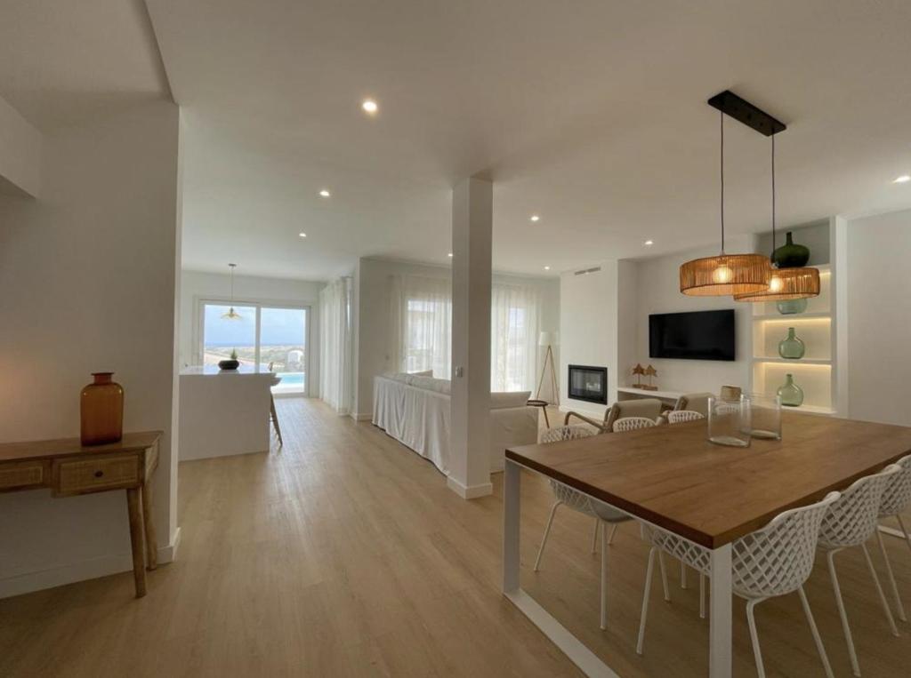 ein Esszimmer und ein Wohnzimmer mit Tisch und Stühlen in der Unterkunft Villa Islander in Cala Morell