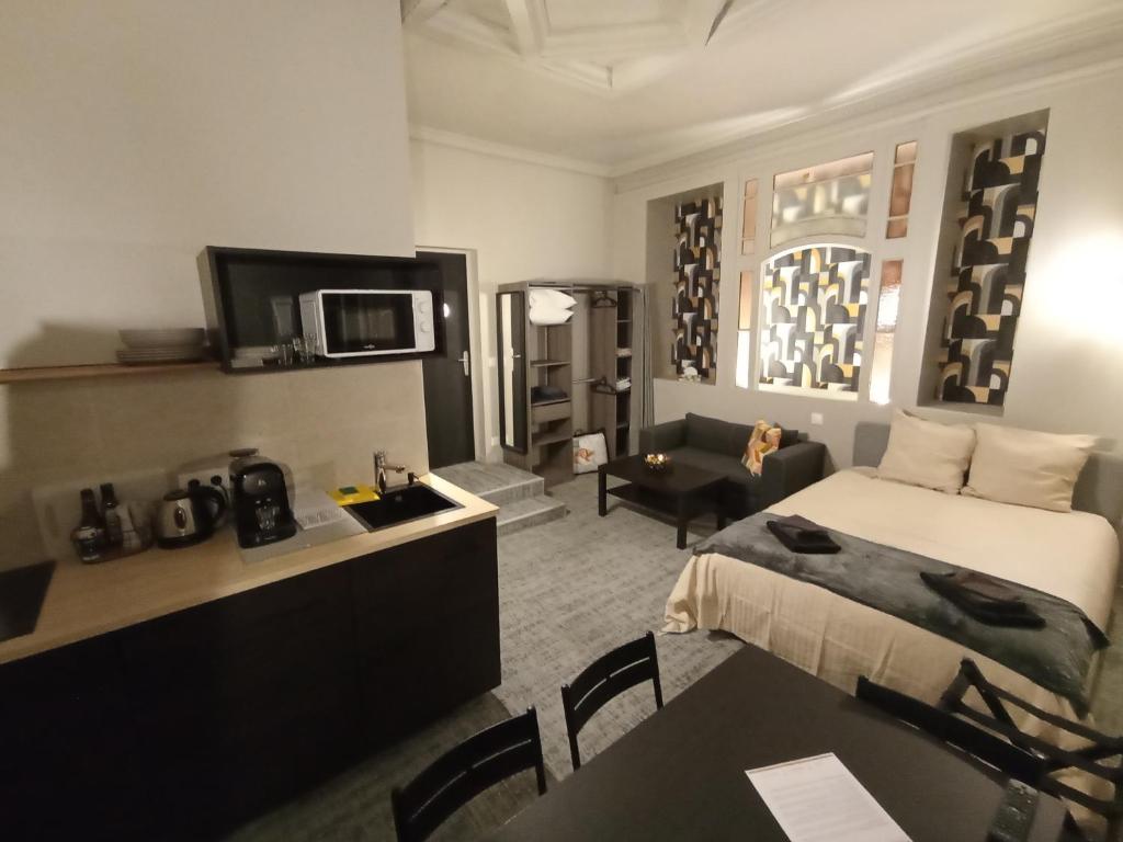 a hotel room with a bed and a living room at Le 12 wifi neuf app 01 in Saint-Étienne