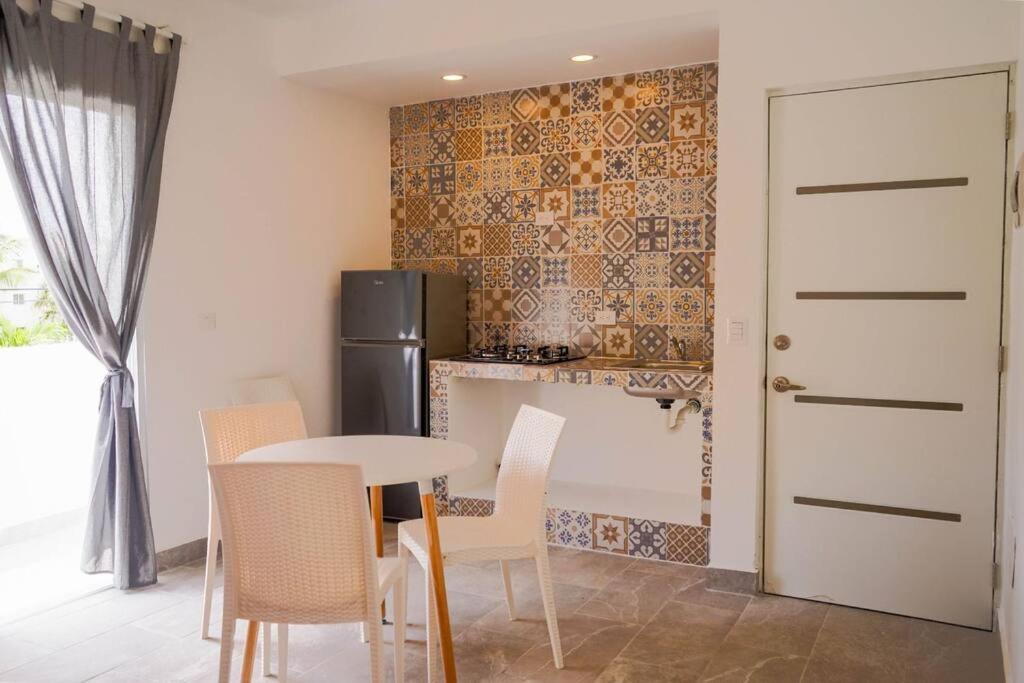 a kitchen with a table and chairs and a refrigerator at Apartamentos estudio amueblados in Punta Cana