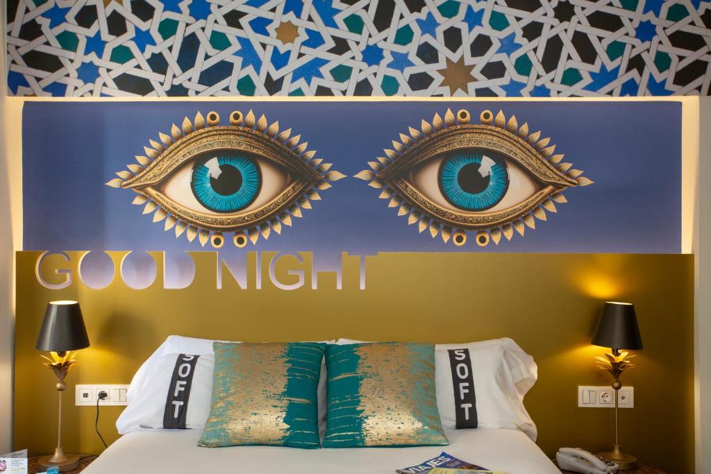 a bedroom with a bed with blue eyes on the headboard at Casual Ilbira Granada in Granada