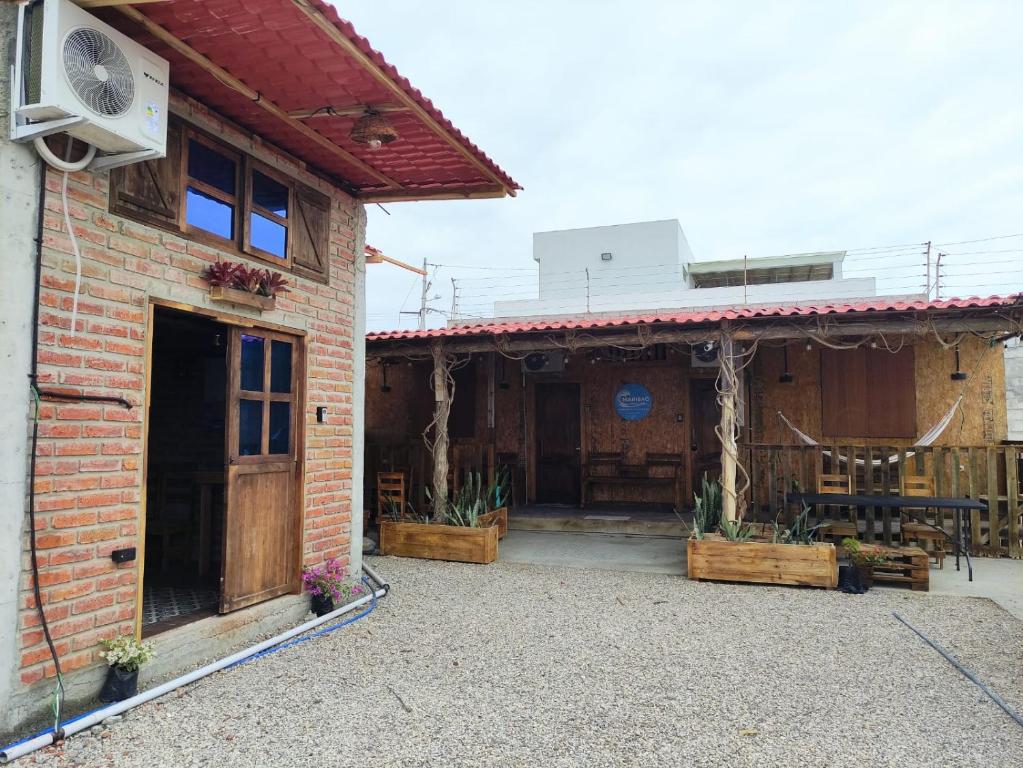 ein Backsteingebäude mit einer Terrasse mit einem Tisch in der Unterkunft MARIBAO in Playas
