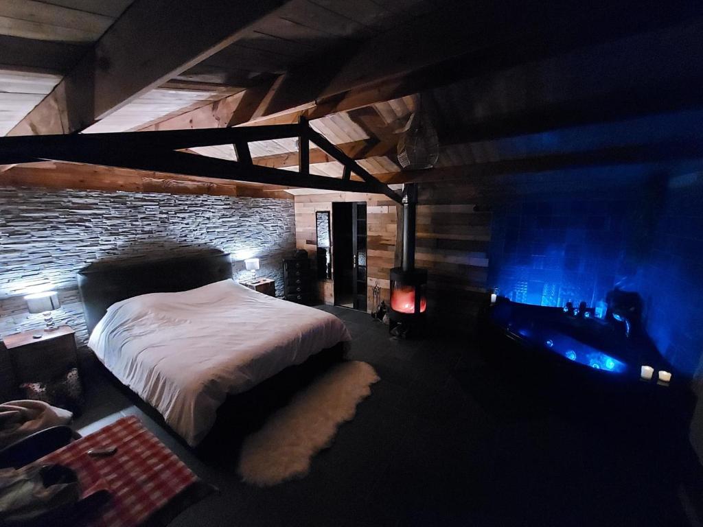 um quarto com uma cama e uma parede de tijolos em La cabane romantique de Milly em Milly-sur-Thérain