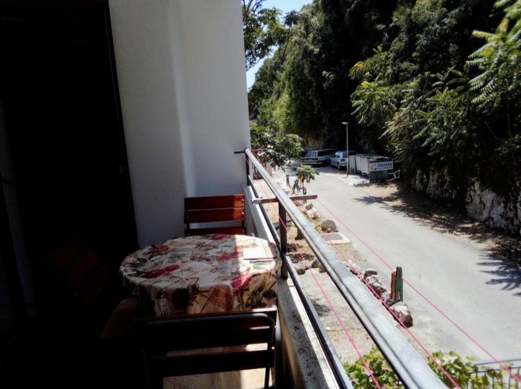 a balcony with a bed and a view of a street at Apartment Željka, Igalo - Herceg Novi in Igalo