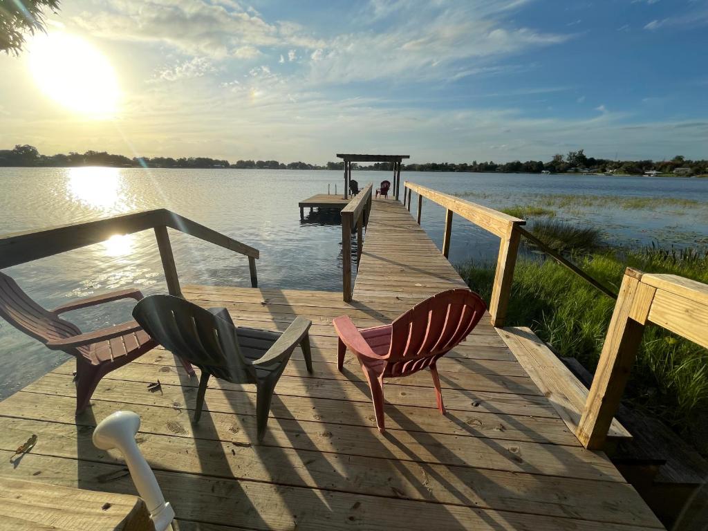 eine Anlegestelle mit zwei Stühlen und einem Tisch auf dem Wasser in der Unterkunft Lake Pearl House in Lake Placid