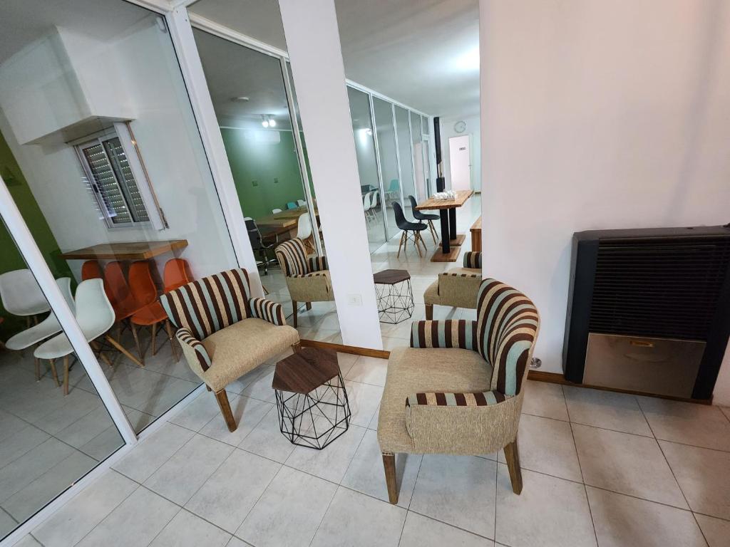 - un salon avec des chaises et un piano dans l'établissement Benja, à General Pico