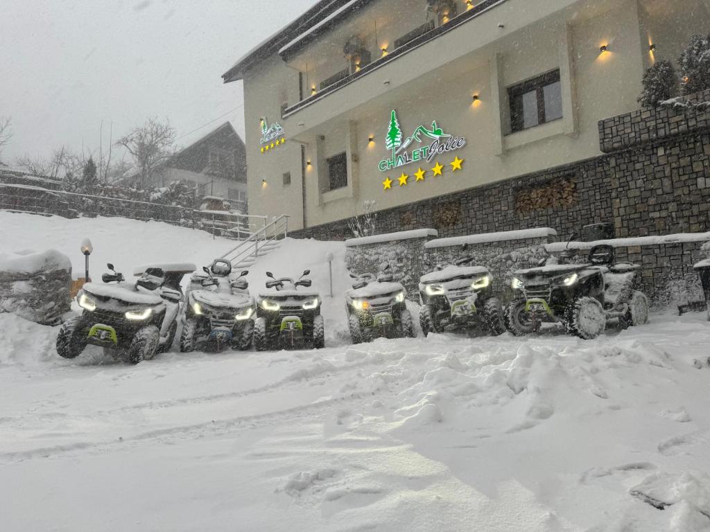 una fila de motos cubiertas de nieve estacionadas frente a un edificio en Chalet jolie Luxury Vila Sinaia, en Sinaia