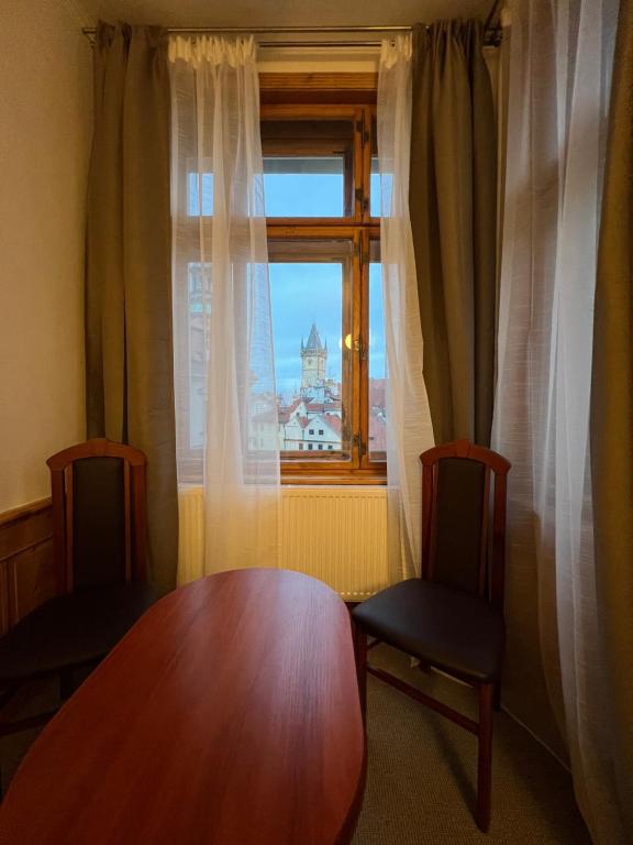 a room with a table and two chairs and a window at Kafka Prague rooms in Prague