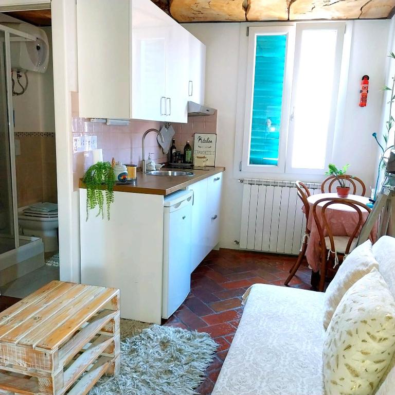 cocina con armarios blancos, fregadero y mesa en Il Nido Del Condor, en Florencia