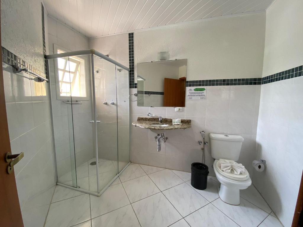 a bathroom with a glass shower and a toilet at Pousada Jordão in Campos do Jordão