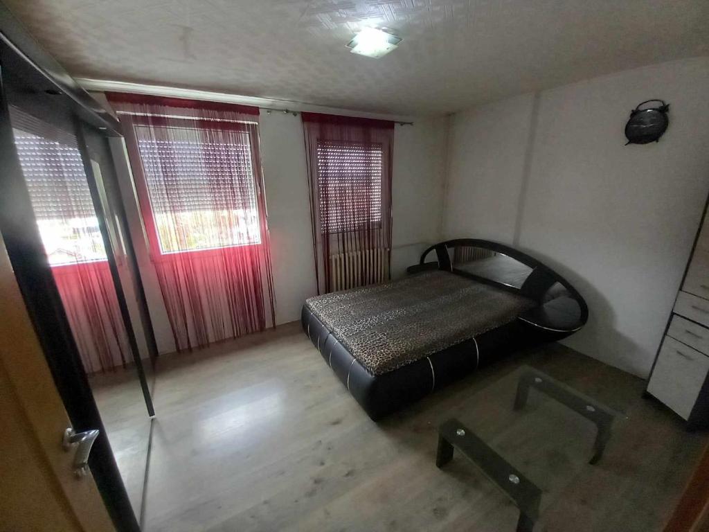 1 dormitorio pequeño con 1 cama y 2 ventanas en Apartman Pava en Bosanska Gradiška