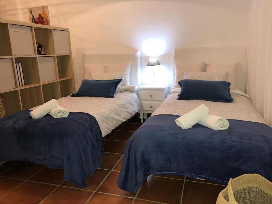 a bedroom with two beds with blue and white pillows at Casa Rodríguez - La Herradura in La Herradura