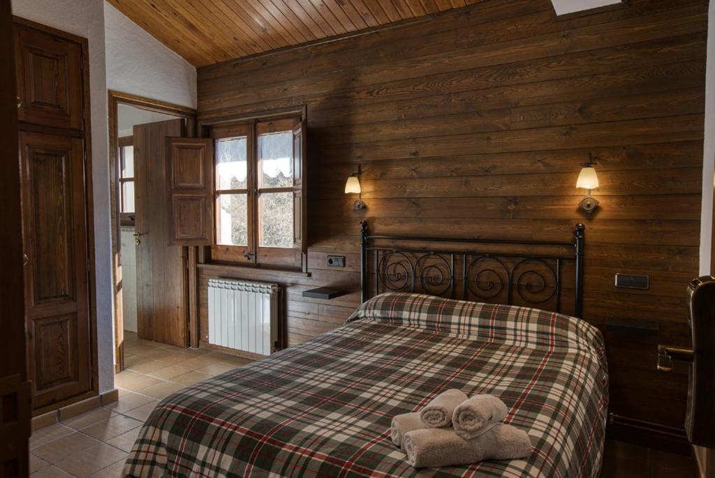 1 dormitorio con 1 cama con toallas en Nastura Casa Rural L'Art, en Rupit