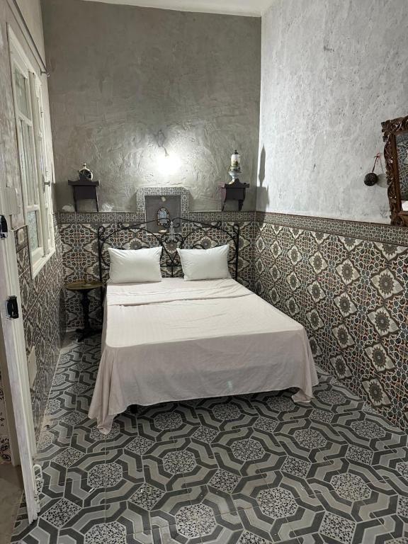 a bedroom with a large bed with white sheets at Dar Nana in Sousse